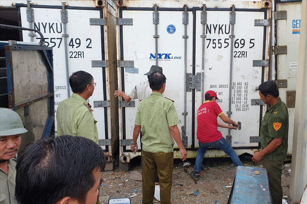 Đoàn kiểm tra container để ở bãi đất trống.