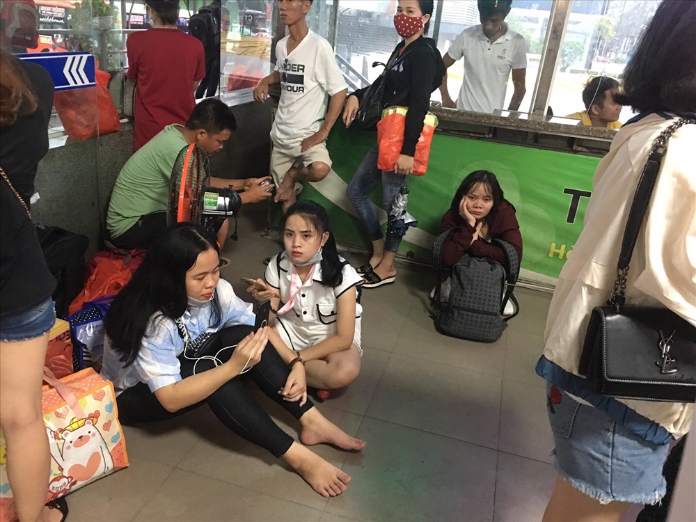 Loa thông báo ở bến xe nước ngầm bắt đầu phát đi thông tin tăng cường xe phục vụ người dân. Nhiều người phải chen chúc xếp hàng mua vé vì cận giờ ghế hết. Khách mua vé ở bến Nước Ngầm hầu hết quê ở xa như Nghệ An, Hà Tĩnh... vì thế thời gian về quê kéo dài 5 - 8 tiếng. Ảnh: Thảo Anh