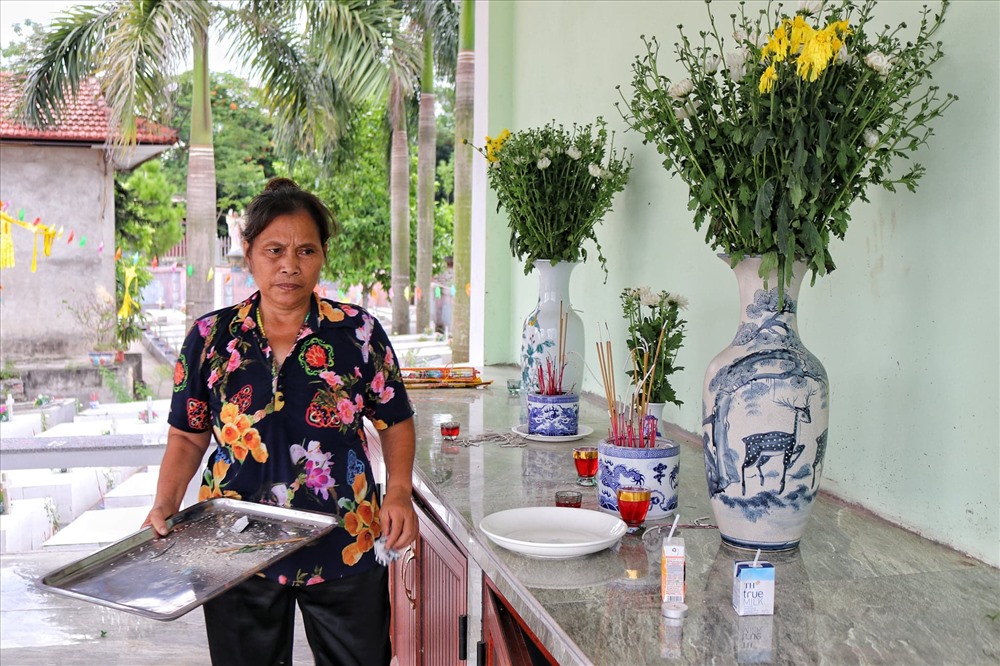 Bà Nguyễn Thị Nhiệm đang lau dọn lại khu nghĩa trang.