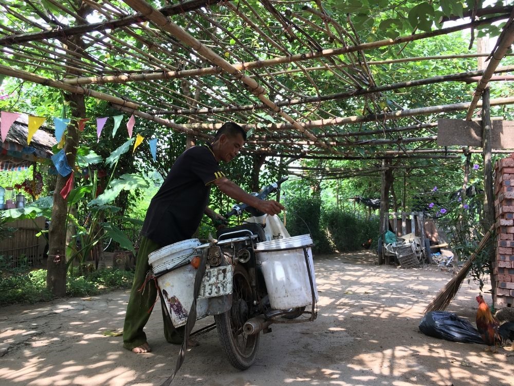 Ông Nguyễn Đăng Được tranh thủ đi vào khu dân cư kiếm nước gạo về chăn nuôi.