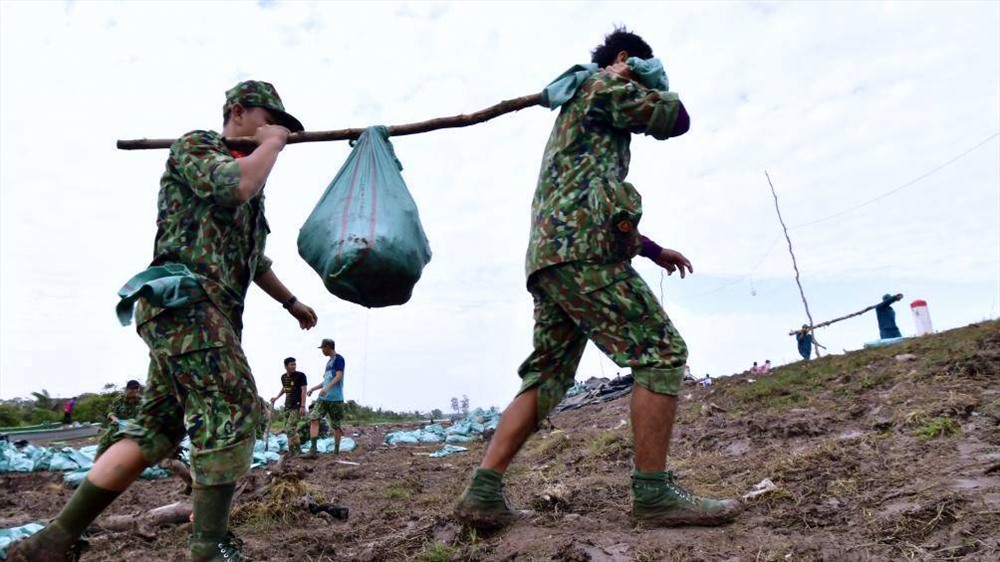 Bộ đội cùng nhân dân ra sức hộ đê (ảnh Nhật Hồ)