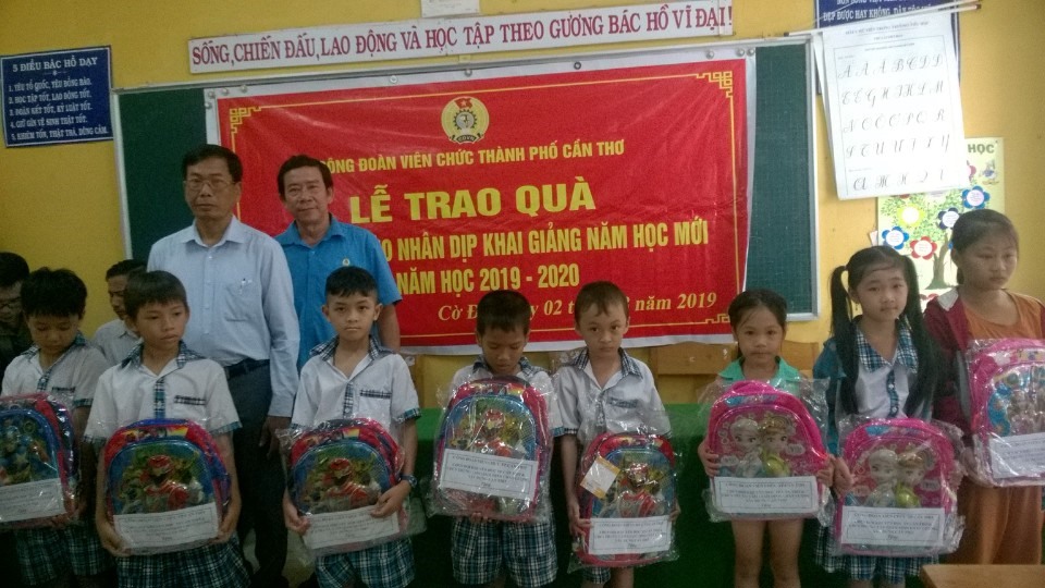 Ông Đoàn Khiêm Hòa và Ông Lê Thành Đô trao quà và chúc mừng các em học sinh nhận quà. Ảnh: Thành Nhân