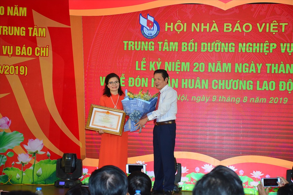 Thứ trưởng Thông tin và Truyền thông Hoàng Vĩnh Bảo trao Bằng khen của Thủ tướng Chính phủ cho Giám đốc Trung tâm Bồi dưỡng nghiệp vụ báo chí Đinh Thị Thuý Hằng. Ảnh: DV