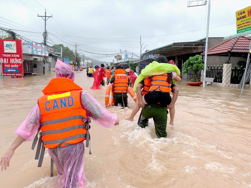 Lực lượng công an cõng người dân di chuyển đến nơi an toàn. Ảnh: LT