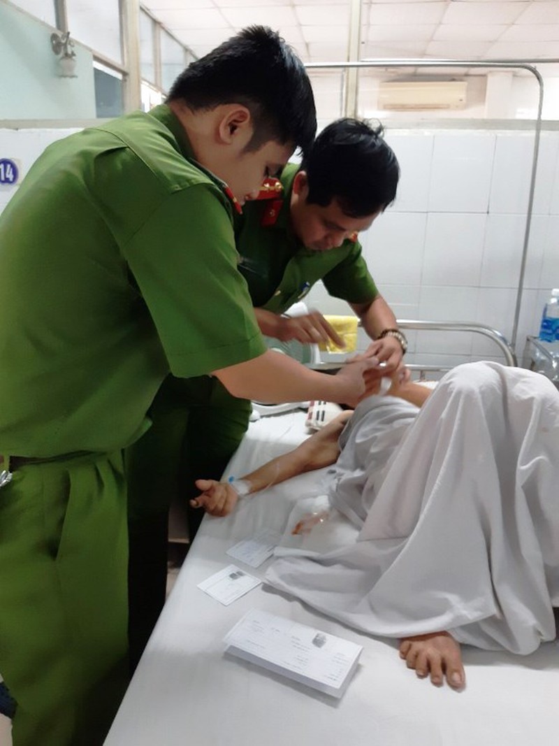 Cán bộ Đội Quản lý hành chính về Trật tự xã hội, Công an quận Cẩm Lệ, TP. Đà Nẵng đến làm giấy CMND cho cụ bà Thôi ngay trên giường bệnh. ảnh: Công an cung cấp.