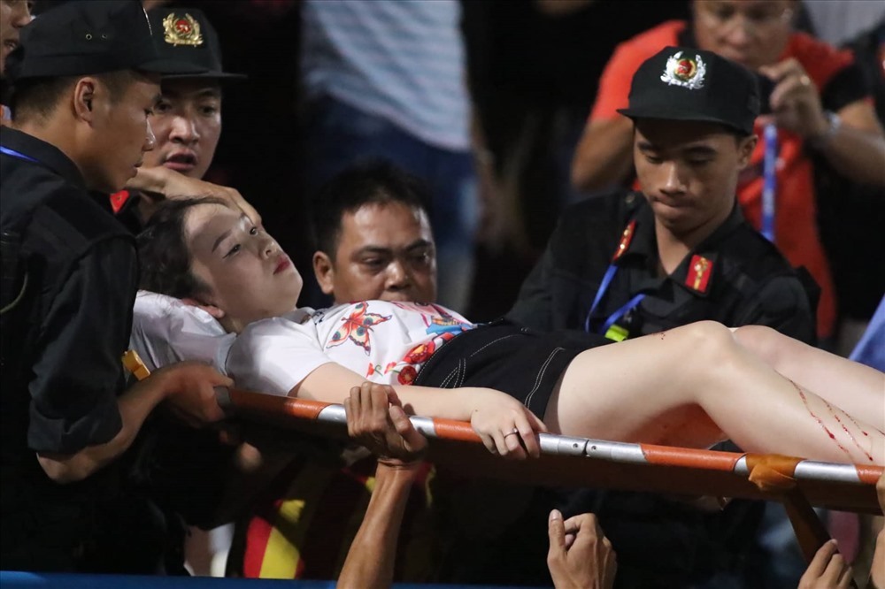 Nữ CĐV được đưa đi cấp cứu với vết thương khá sâu ở đùi phải. Ảnh: Trần Tiến