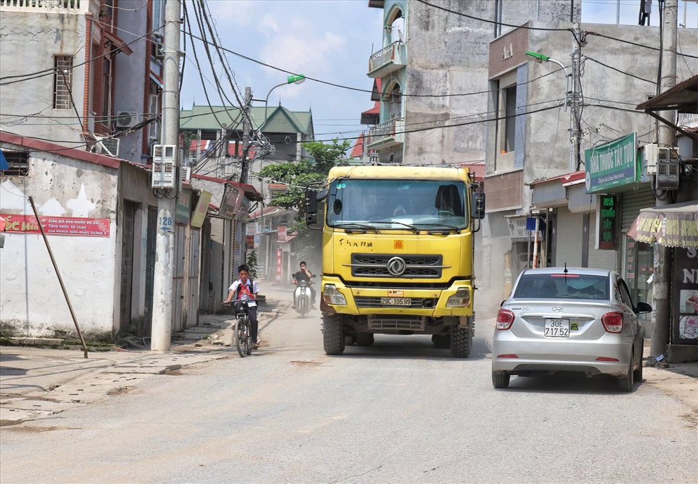 Tuyến đường Tây Tựu thường xuyên bị binh đoàn xe quá tải “tra tấn” ngày đêm. Ảnh: Thái Hà.