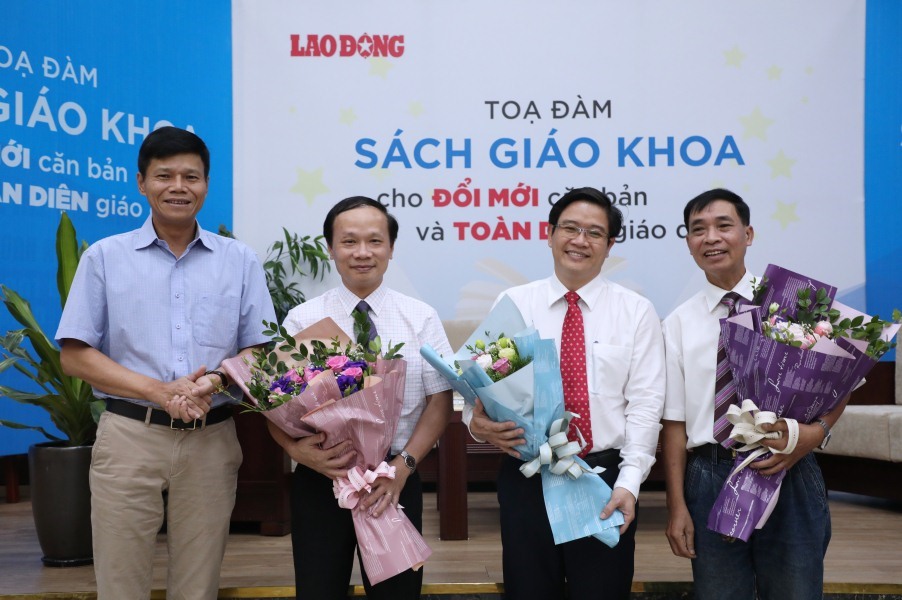 Uỷ viên Đoàn Chủ tịch Tổng LĐLĐVN, Tổng Biên tập Báo Lao Động Nguyễn Ngọc Hiển (ngoài cùng bên trái) tặng hoa cho các khách mời tham gia toạ đàm “Sách giáo khoa cho đổi mới căn bản và toàn diện giáo dục”. Ảnh: TÔ THẾ