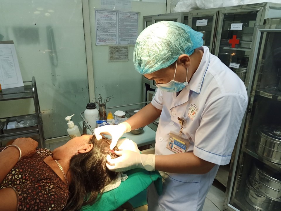Mẹ bệnh nhân P được kiểm tra vết thương đầu.