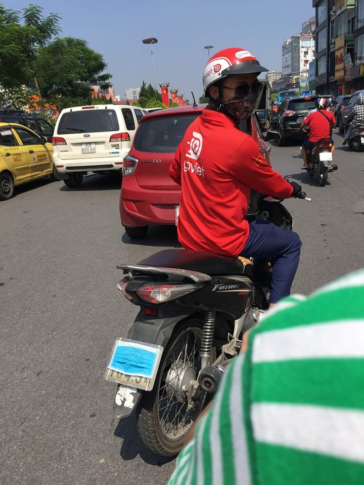 Lái xe ôm công nghệ cố tình che biển số xe bằng khẩu trang. Ảnh: Q.H
