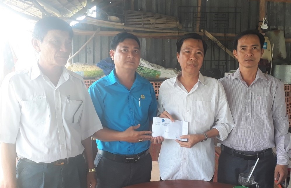 Lãnh đạo LĐLĐ huyện Long Mỹ trao hỗ trợ cho đồng chí Tùng. Ảnh: Hoài Phúc