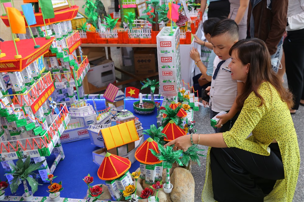 Phụ huynh học sinh và các em nhỏ thích thú xem các đồ dùng, đồ chơi, mô hình từ vỏ hộp sữa đã qua sử dụng tại Ngày hội SHĐ Đà Nẵng.