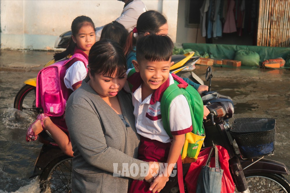 Nhiều em nhỏ được phụ huynh cõng đến trường, đa số tỏ ra thích thú trước cảnh “nước lớn“.