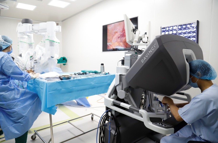 Các bác sĩ điều khiển robot phẫu thuật nội soi cho bệnh nhân ung thư tại bệnh viện K. Ảnh: T.H