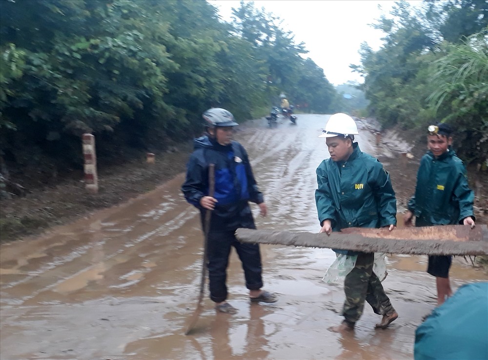 Anh Vai (bìa phải ảnh) cùng người dân, cán bộ xã và biên phòng bật đèn pin dọn các điểm đường bị nghẽn từ lúc 4h sáng đến trưa. Ảnh: Chí Tuấn.