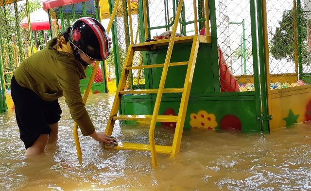 Giáo viên Trường Mầm non Hà Lĩnh lau dọn ngay khi nước đang rút dần