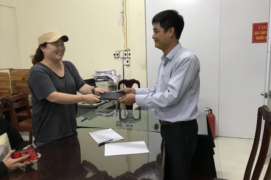 Đại diện hãng taxi Hàng Không trao trả tài sản lại cho du khách Hàn Quốc bỏ quên trên xe. ảnh: V.X.