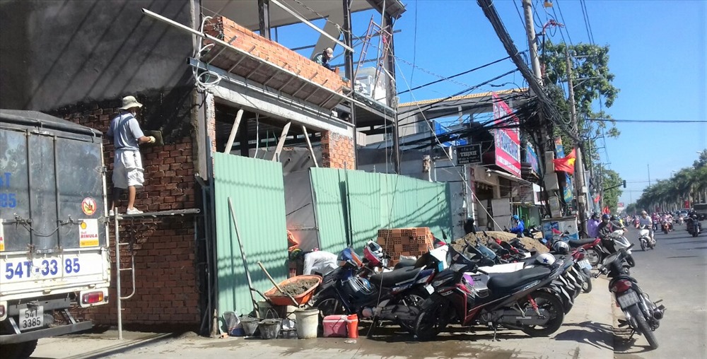 Theo một số người dân, quá trình thi công để vật liệu xây dựng và xe môtô lấn chiếm trên vỉa hè cũng tạo ra tiềm ẩn nhiều nguy cơ gây mất an toàn giao thông. Ảnh: Thành Nhân.