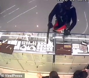 Nghi phạm chĩa súng vào người bán hàng. Ảnh: Viral Press