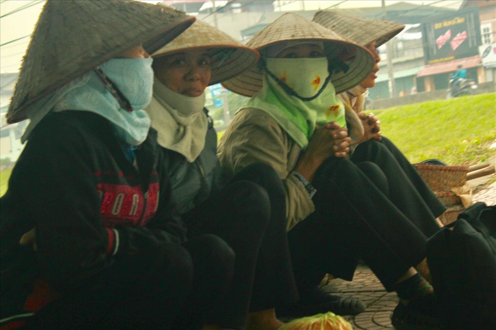 Người lao động nghèo ngồi vạ vật chờ đợi có người đến thuê làm.