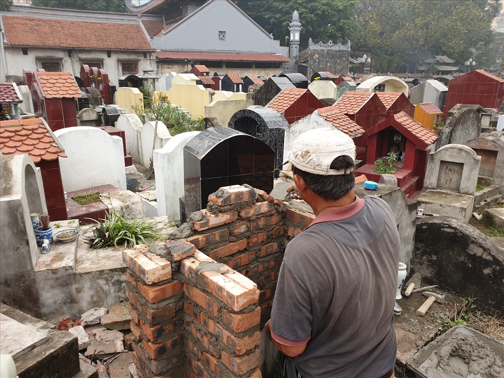 Người thợ đang tu sửa lại phần mộ cho người đã khuất. Ảnh: Kiều Giang