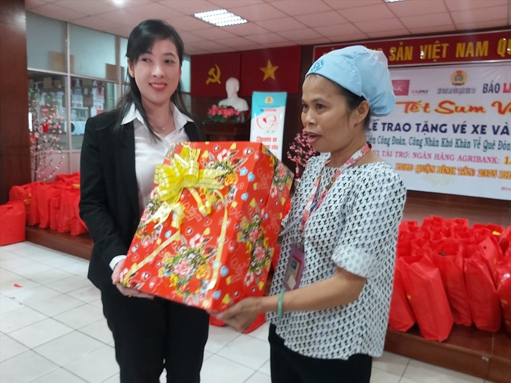 Đặng Thị Thanh Nga, Giám đốc Phòng Giao dịch chi nhánh AgriBank Khu công nghiệp Tân Tạo, tặng quà cho chị Đậu Thị Lê, Cn Công ty PouYuen, quê ở Nghệ An, một mình phải nuôi hai con nhỏ và chồng bị bệnh không làm việc được. Ảnh Nam Dương