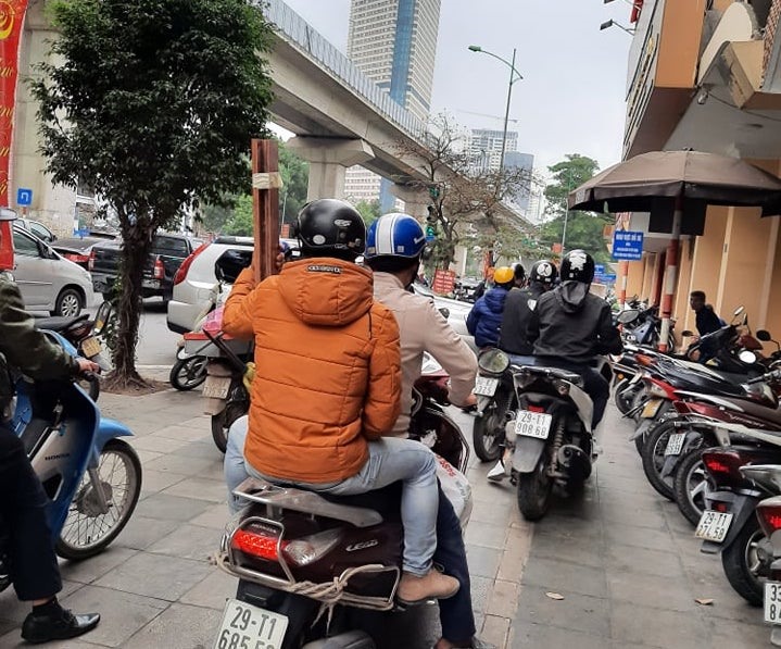 Ùn tắc giao thông, nhiều người không ngần ngại đi xe máy trên vỉa hè. Ảnh PV