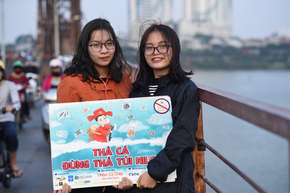 “Đây là lần đầu tiên chúng mình tham gia chương trình đường Táo quân. Gió lớn trên cầu chắc chắn cũng không làm giảm đi tinh thần của chúng mình. Công việc cầm biển tuyên truyền này có ý nghĩa rất lớn và không hề nhàm chán như mình đã nghĩ. Người dân đi qua đều chú ý, và mình nghĩ họ sẽ thay đổi nhận thức khi thấy chúng mình làm công việc này“- hai bạn tình nguyện viên của nhóm chia sẻ. Ảnh: Đ.T.Q