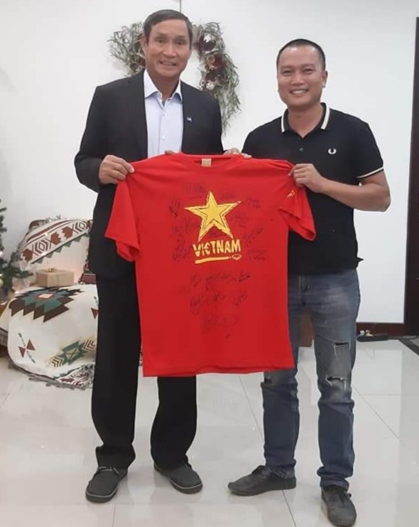HLV Mai Đức Chung trao tặng chiếc áo có chữ ký của ông và các cầu thủ đội tuyển bóng đá nữ quốc gia cho anh Phạm Đình Quý. Ảnh: Phạm Đình Quý