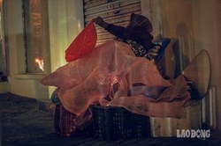 Hà Nội giá rét, người vô gia cư dùng áo mưa thay chăn để chống lạnh