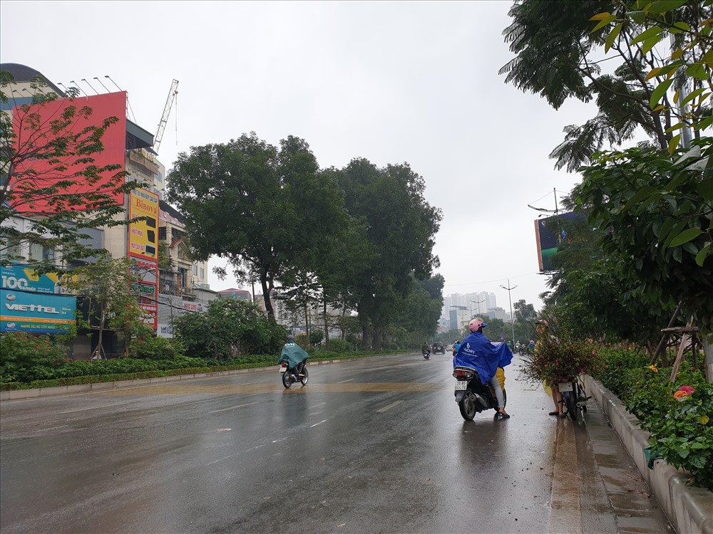 Dù trời đổ mưa, mộ số người dân vẫn cố nán lại mua cành đào, quất để kịp về với gia đình ngày 30 Tết. Ảnh: TG.