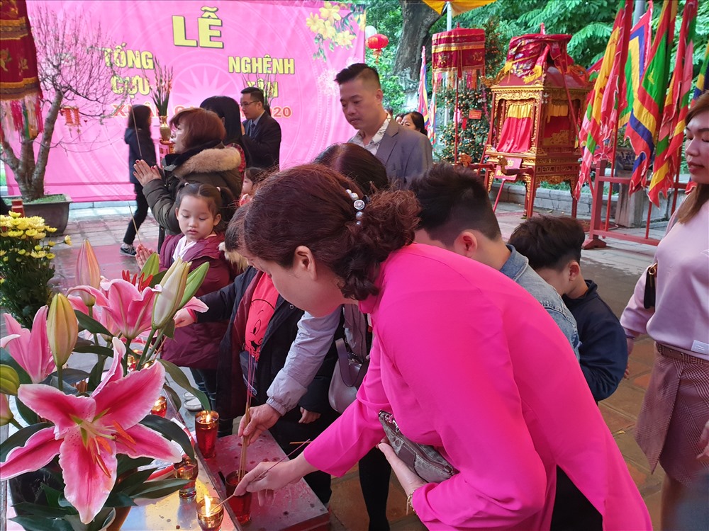 Bà mẹ dạy con hướng Phật. Ảnh: Tùng Giang.