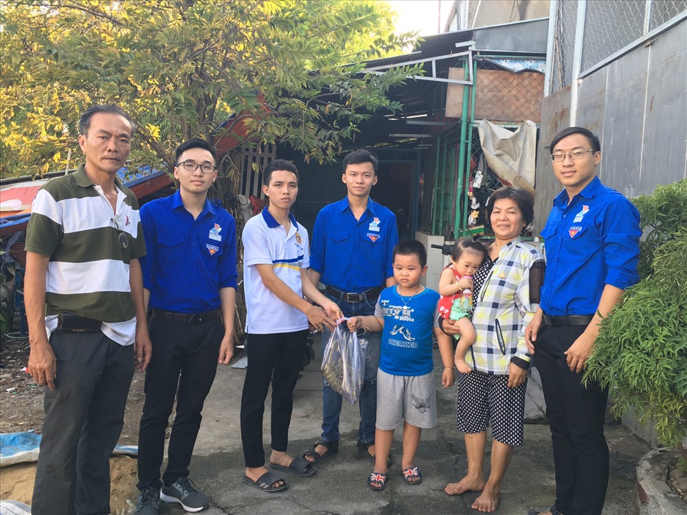 Đại diện khu phố và sinh viên trao bánh cho hộ gia đình khó khăn