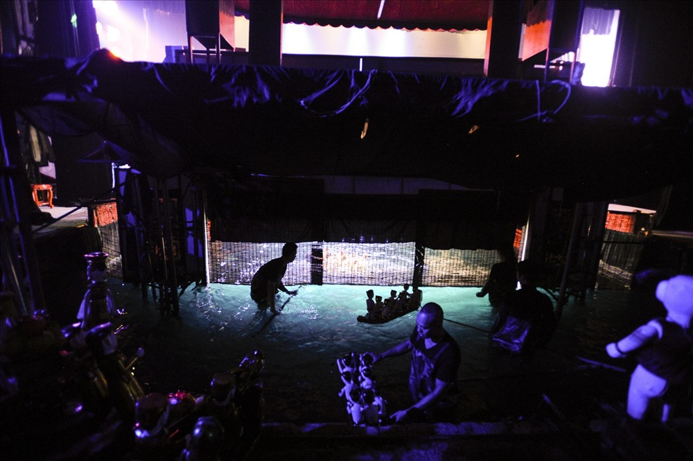 Phía sau tấm rèm là mọi bí mật của múa rối nước, là nơi các nghệ sĩ biểu diễn chìm trong bóng tối với những cây gậy điều khiển.