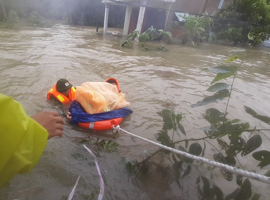 Lực lượng chức năng huyện Phú Ninh đang giải cứu cháu 1 tuổi cùng mẹ bị mắc kẹt trong lũ.