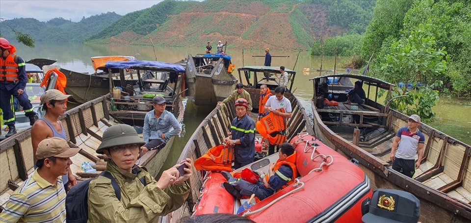 Các công nhân được tìm thấy được đưa ra khỏi lòng hồ thủy điện bằng thuyền. Ảnh: Phan Thiên Định