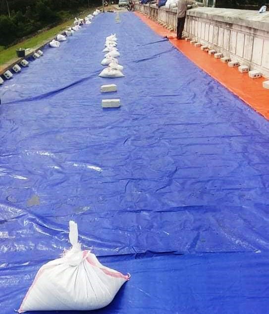 Dùng bạt che vết nứt để ngăn nước ngấm sâu vào bên trong. Ảnh: NT
