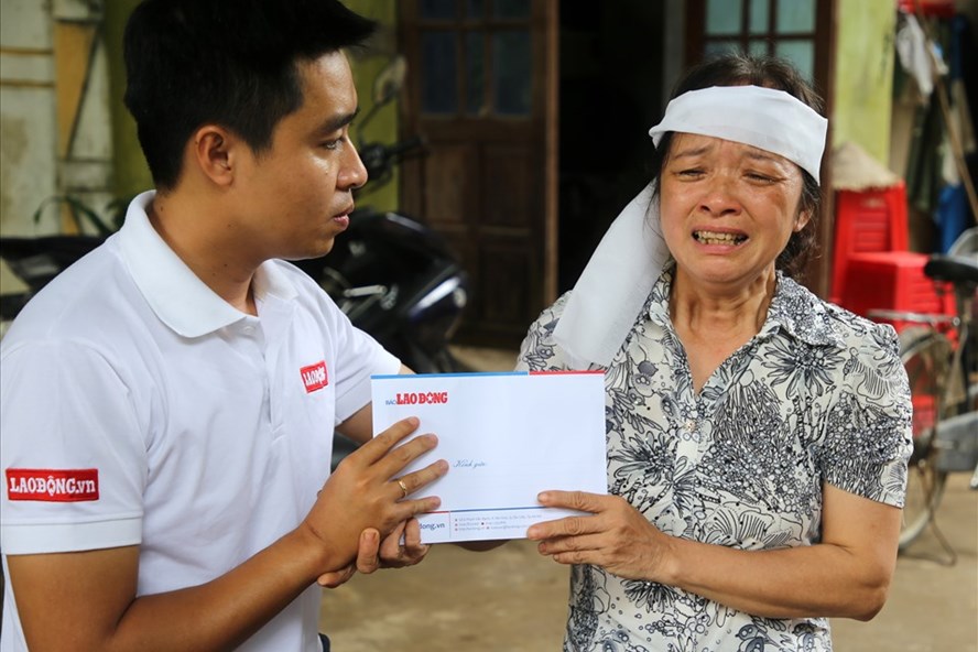 Đại diện Quỹ XHTT Tấm lòng Vàng Lao Động trao tiền hỗ trợ cho gia đình có nạn nhân bị thiệt mạng do nước lũ cuốn. 
Ảnh: Hưng Thơ