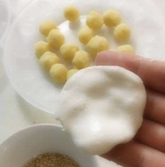 Nặn bột thành hình dẹt để bao phần nhân đậu xanh vào trước khi cho bánh lên chiên. Ảnh: Nguyễn Thu Hương.