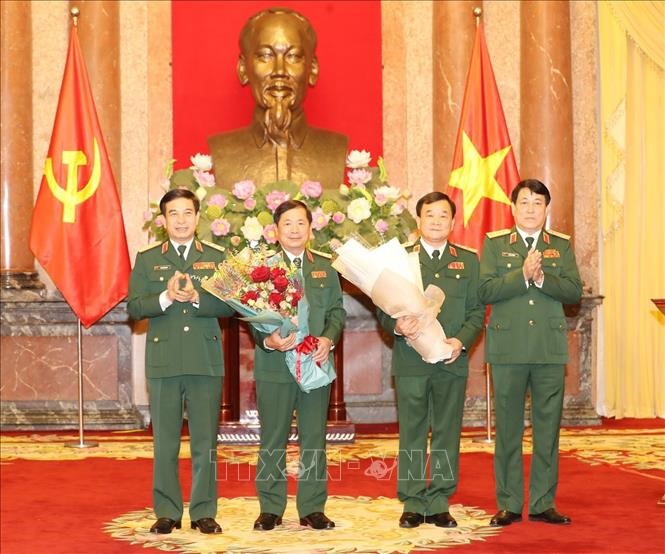 General Luong Cuong, Secretary of the Party Central Committee, Chairman of the General Political Department of the Vietnam People's Army and Senior Lieutenant General Phan Van Giang, Member of the Party Central Committee, Chief of Staff of the Vietnam People's Army presented flowers for congratulate 2 generals just promoted to rank.  Photo: Tri Dung / VNA