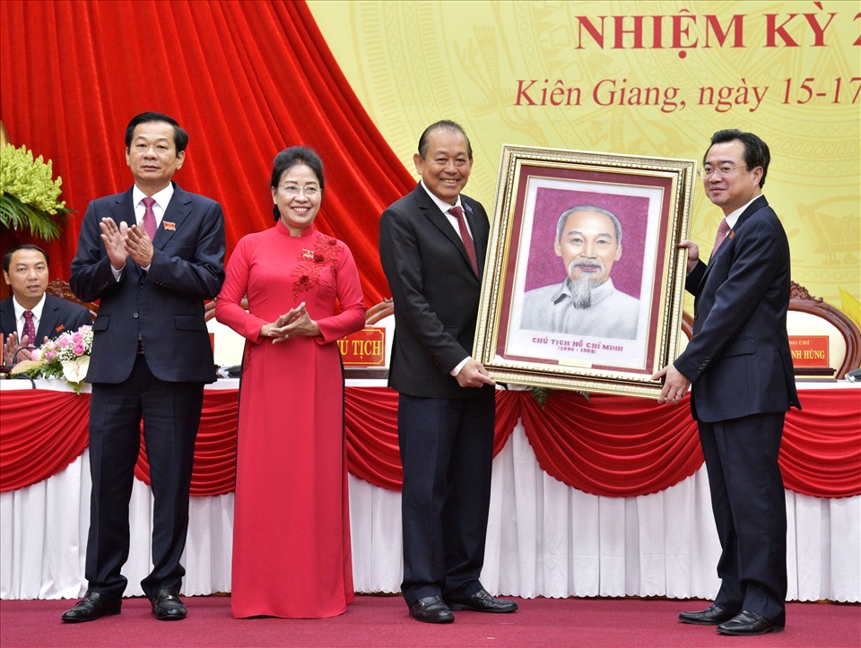 Mr. Do Thanh Binh (left cover of photo) and the leaders of the Kien Giang Provincial Party Committee, period X, received congress gifts from Permanent Deputy Prime Minister Truong Hoa Binh.  Photo: BTC meeting provided.