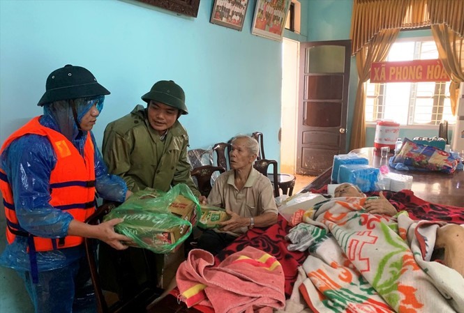 Vài giờ trước khi vào Thủy điện Rào Trăng 3 cứu công nhân gặp nạn và qua đời, anh Nguyễn Văn Bình (giữa) – Chủ tịch UBND huyện Phong Điền (Thừa Thiên Huế) vẫn còn tham gia cứu trợ đồng bào Phong Điền bị mưa lũ. Ảnh: PCTT