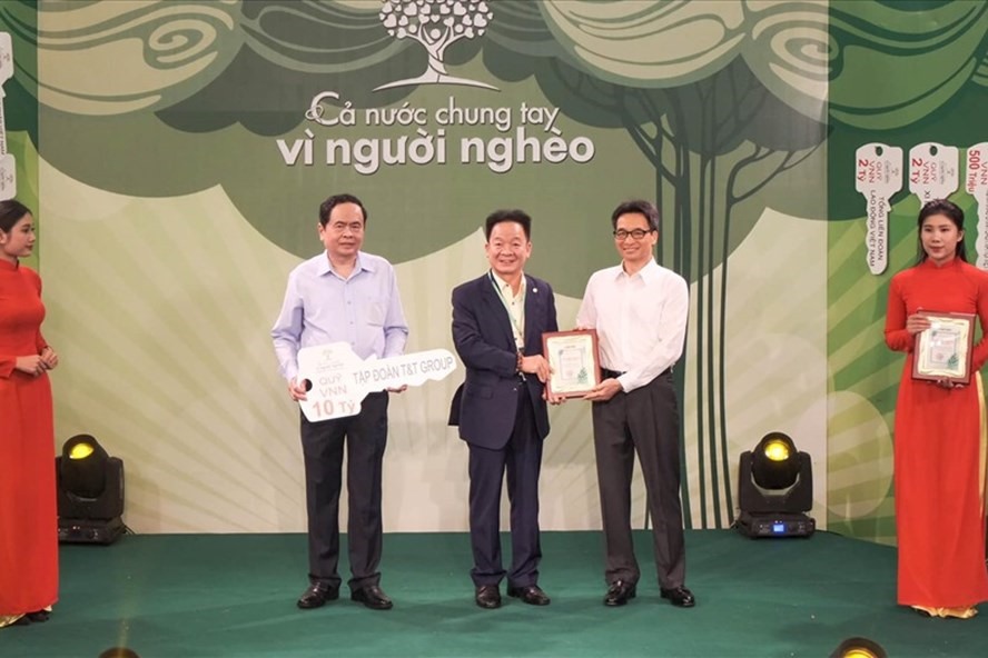 Bầu Hiển trao tiền đến quỹ “Vì người nghèo“. Ảnh: Trung Nguyễn