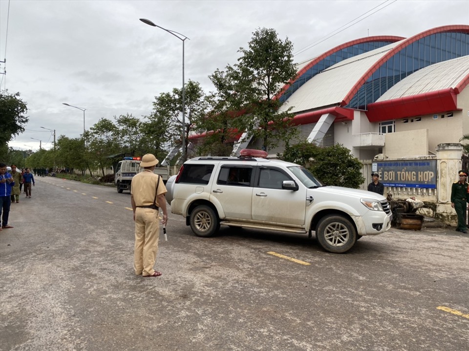 Cảnh sát giao thông hướng dẫn đoàn xe chở thi hài quân nhân hi sinh do bị vùi lấp vào điểm tập kết. Ảnh: QĐ