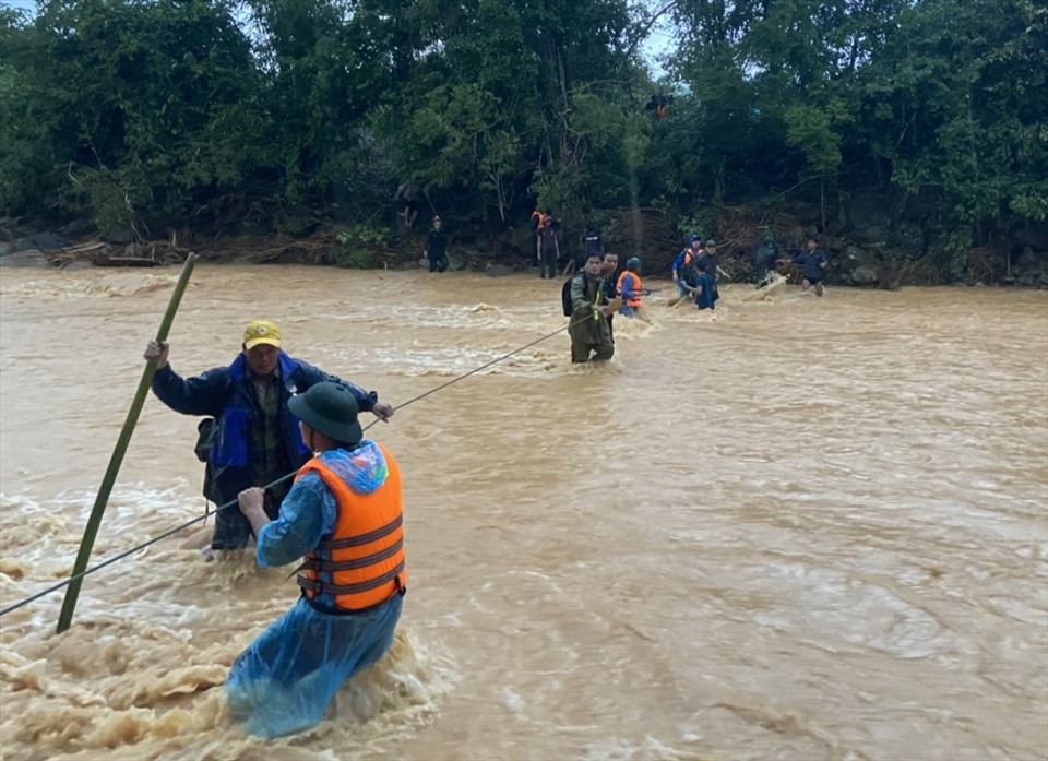 Pass a rope through the floodwaters to remove the body of a companion from the isolated area.  Photo: VQ.