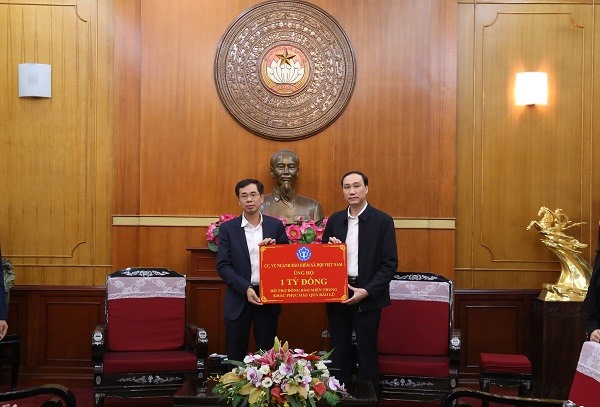 Phó Tổng Giám đốc Bảo hiểm xã hội Việt Nam Đào Việt Ánh trao số tiền hỗ trợ đồng báo miền Trung bị bão lũ của Ngành BHXH đến Trung ương Mặt trận Tổ quốc Việt Nam. Ảnh BHXH VN