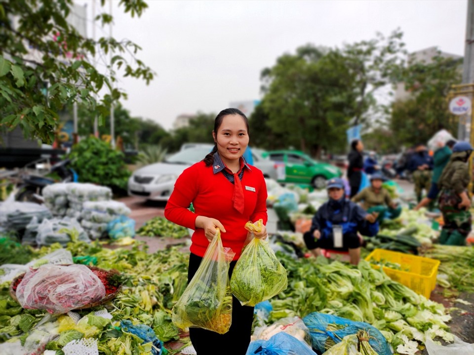 Chị Huyền (một người dân tại TP. Hà Tĩnh) tỏ ra phấn khởi khi mua được rau, thịt tại khu chợ, để bù đắp thiếu thốn trong những ngày lũ vừa qua. Ảnh: Quách Du