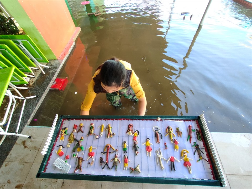 Một cô giao Trường mầm non Thạch Tân (xã Tân Lâm Hương, huyện Thạch Hà, Hà Tĩnh) don dẹp đồ trong nước lũ. Ảnh: Quách Du