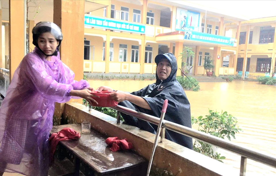 Tại một số trường học chưa rút hết nước lũ thì giáo viên tranh thủ dọc ở tầng trên để bảo đảm công tác vệ sinh. Ảnh: LPL