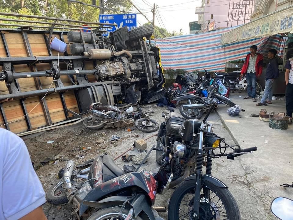 Chiếc xe tải chở bia lật ngang trước khi lùa hàng chục xe máy, đâm gãy trụ điện. Ảnh: Phi Thanh